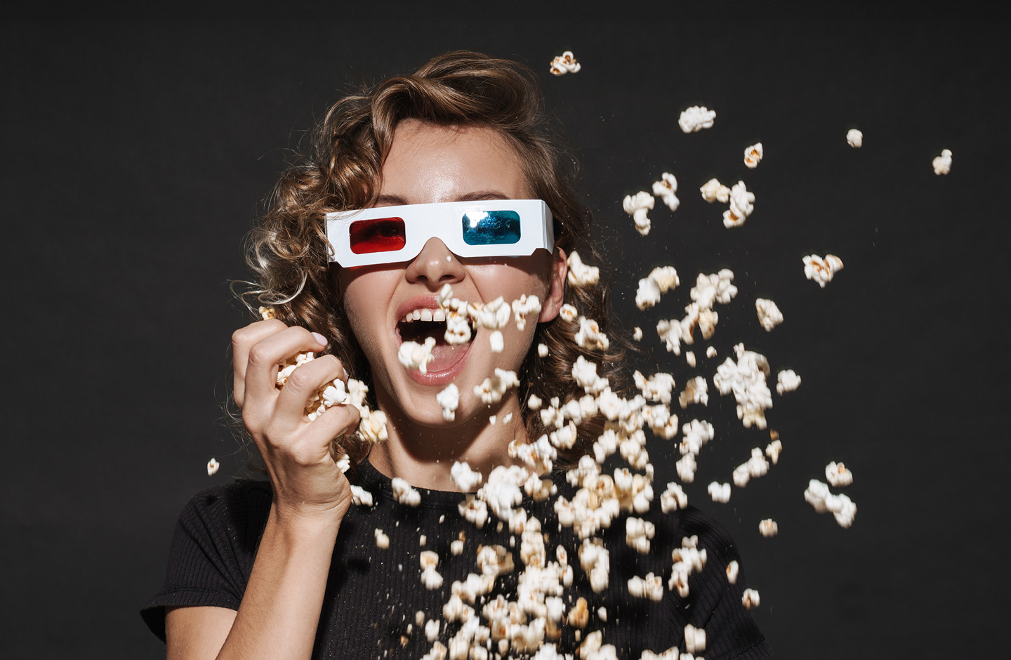 Ein Mädchen sitzt im Kino und isst Popkorn