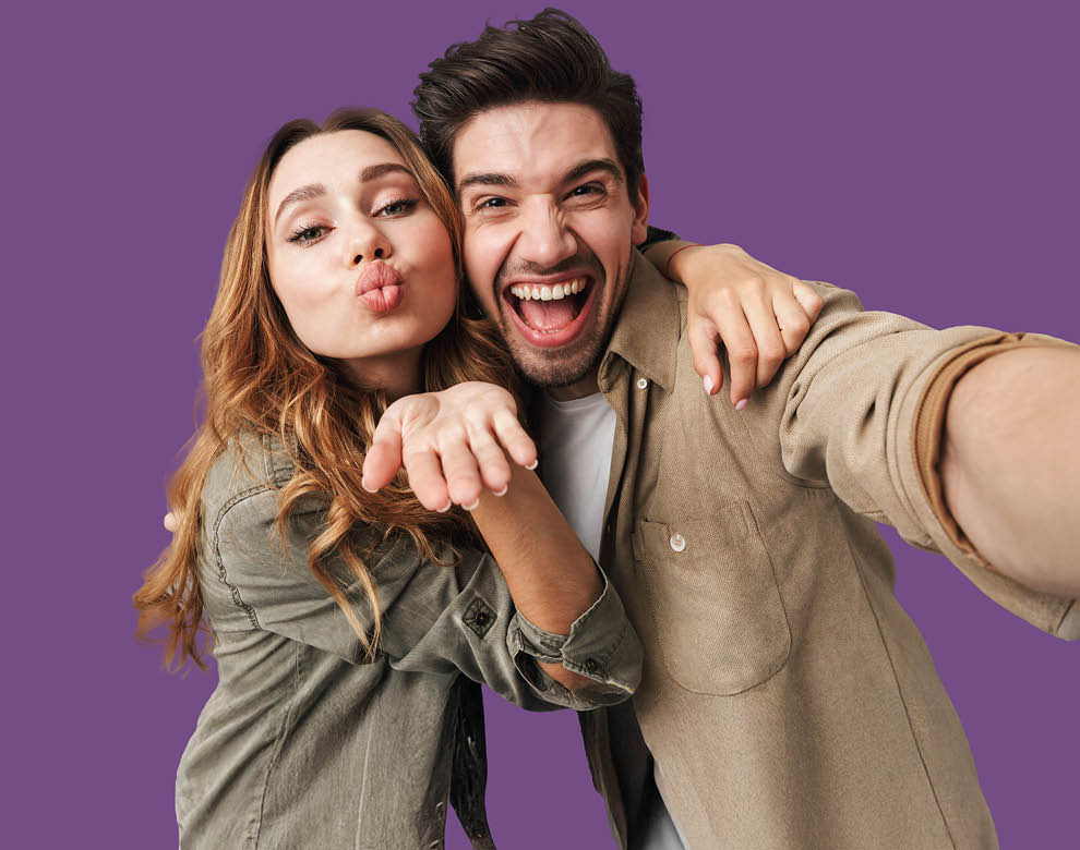 Junger Mann lächelt und junge Frau zeigt Kuss-Mund