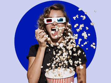 Mädchen mit Kinobrille wirft Popcorn in die Luft
